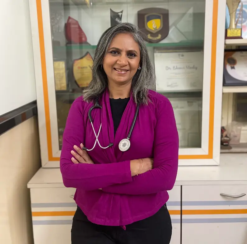 Dr. Bhavi Mody, homeopathy and nutrition doctor, standing with a stethoscope in her Mumbai clinic