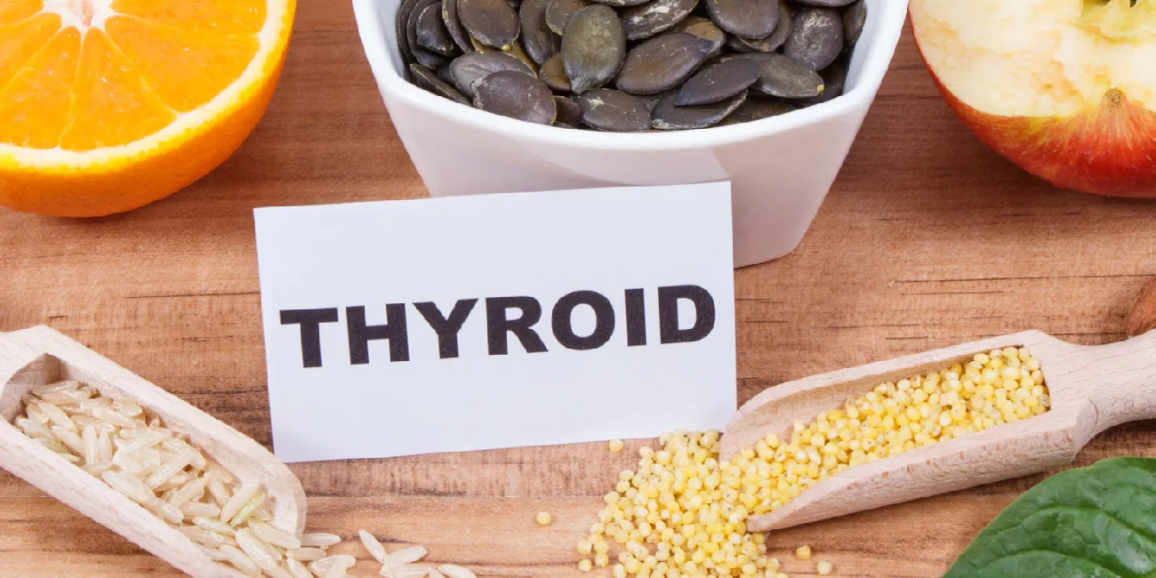 Thyroid meal planning with pumpkin seeds, millet, brown rice and fresh fruit beside a thyroid card